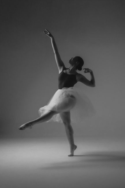 A graceful ballet dancer posing elegantly in a tutu, captured in a classic black and white style.