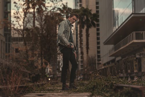 Man Standing on Pathway With Plants