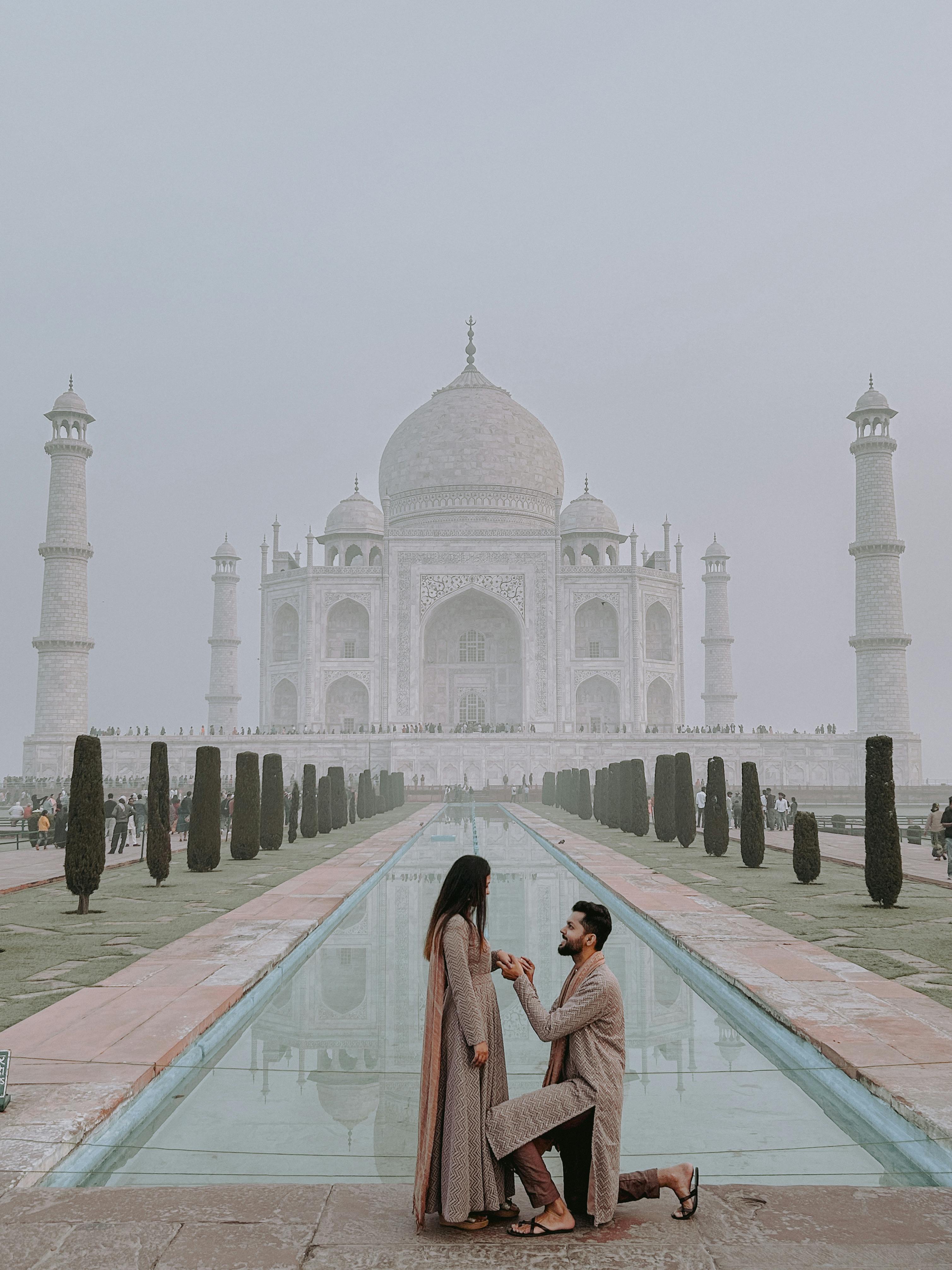 free photo of man proposing to a woman in front of the taj mahal palace india