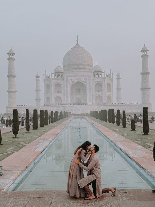 Free A romantic couple kissing in front of the iconic Taj Mahal in Agra, India. Stock Photo