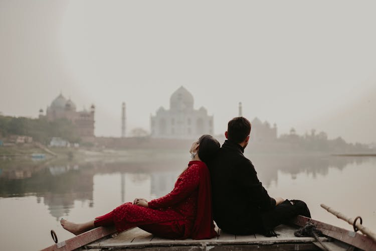 Couple Sitting On Boat On River