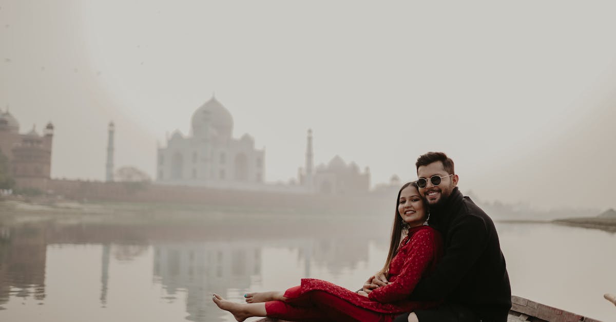 A couple enjoying a serene boat ride with the Taj Mahal in the backdrop, reflecting on the calm river.
