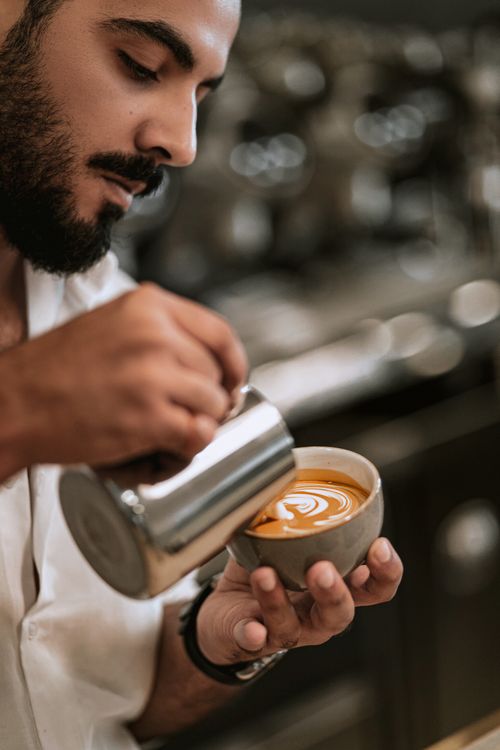 Free A barista skillfully pours latte art into a cup of coffee in a Baku cafe. Stock Photo