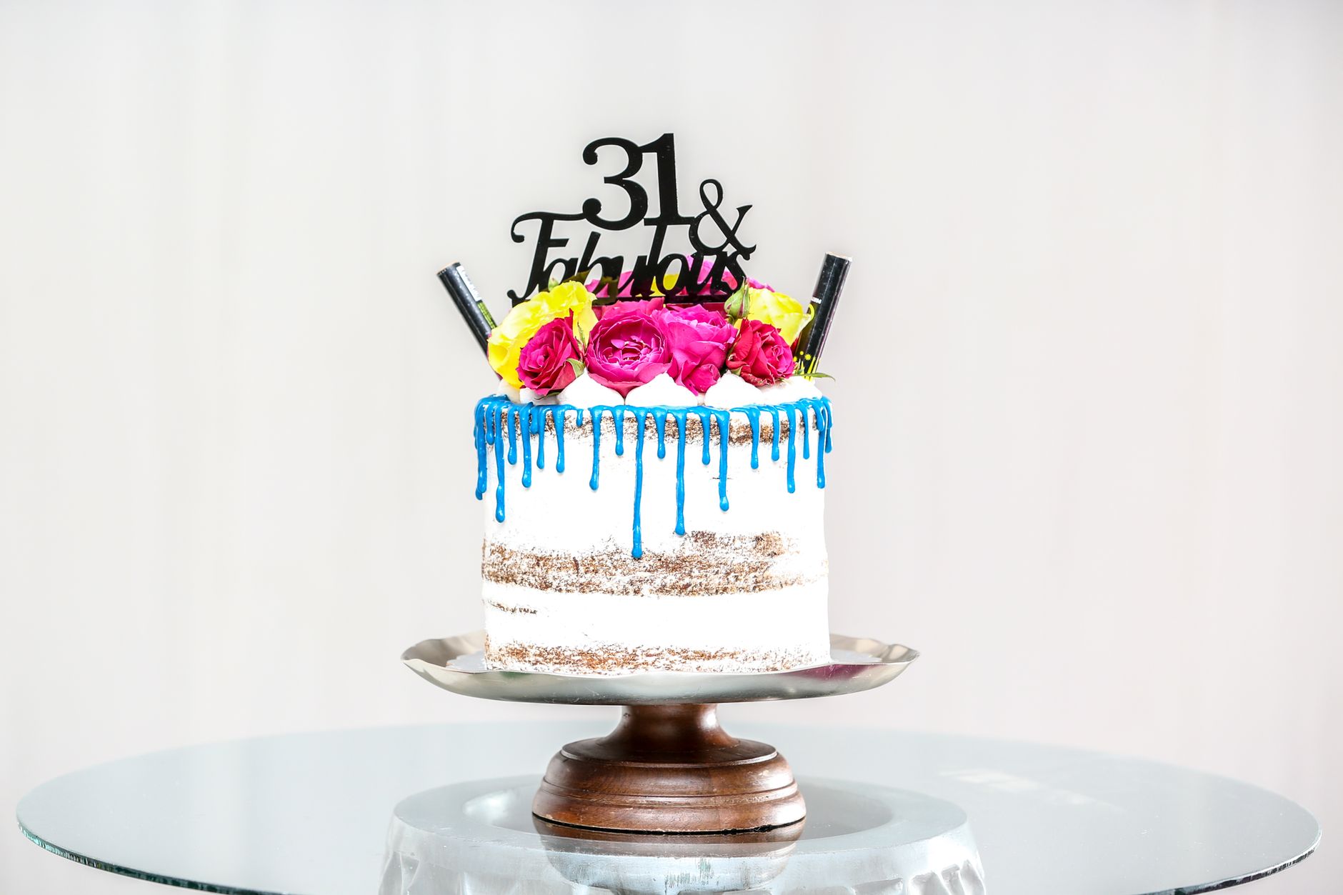 A stylish birthday cake with flowers and blue icing perfect for celebrations.