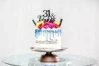 这款时尚的生日蛋糕，上面装饰着鲜花和蓝色糖霜，非常适合庆祝活动