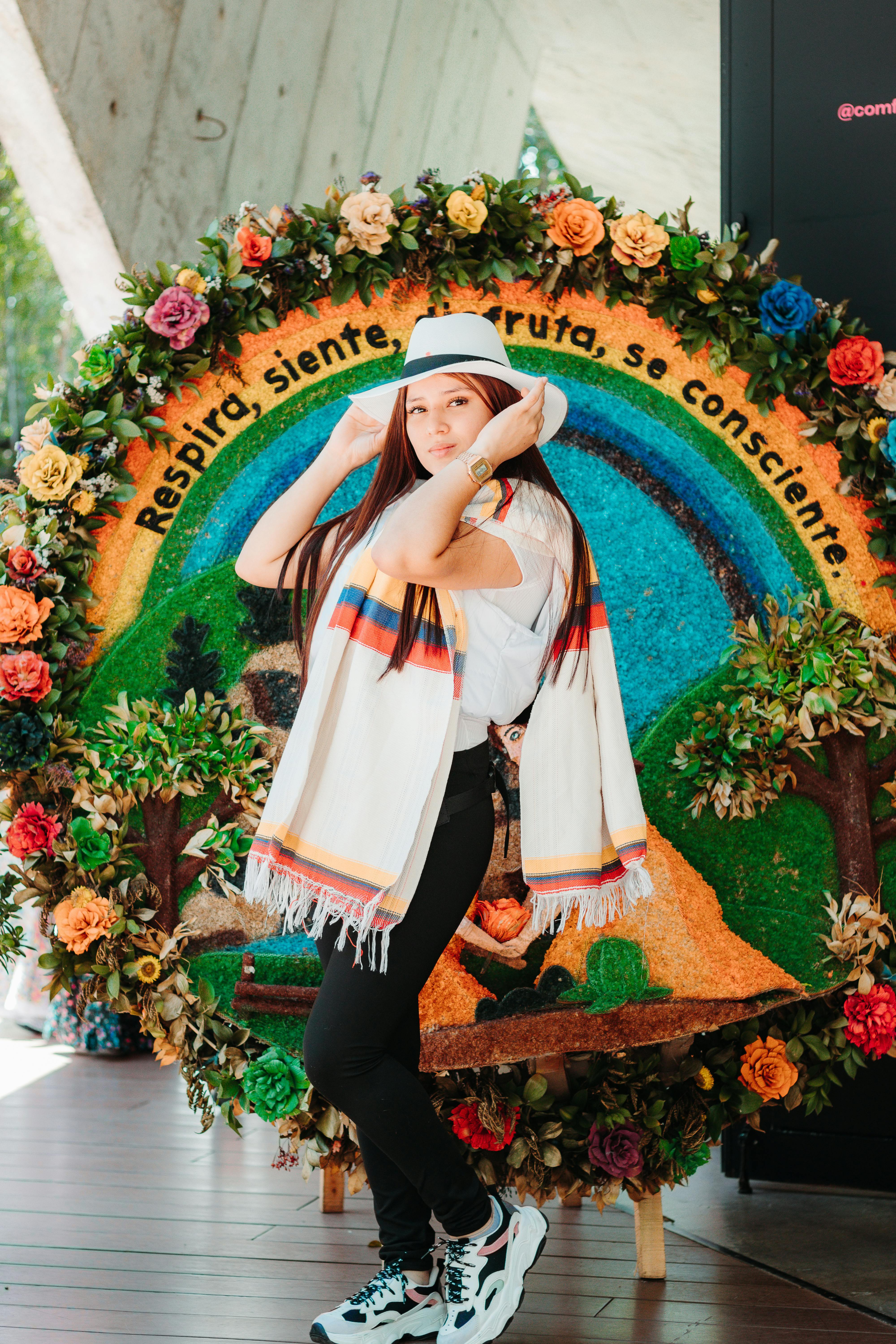 Woman in traditional Colombian attire posing with floral art background in Santa Elena.