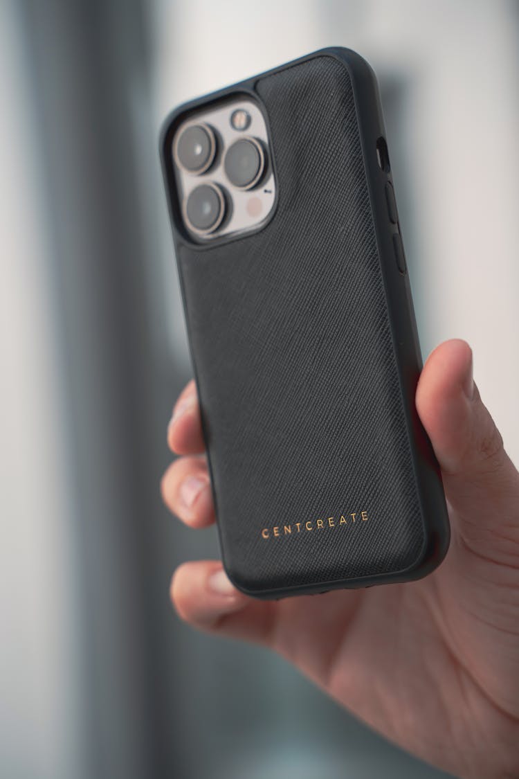 Close-up Of A Person Holding An IPhone In A Black Case