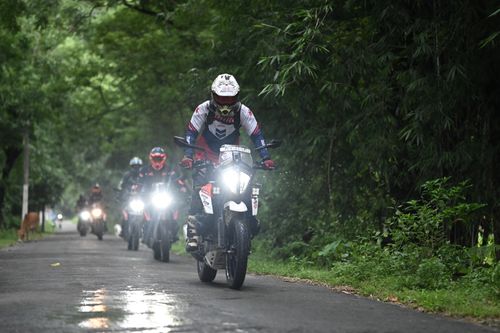Free Motorcyclists riding through a lush forest road in Guwahati, India. Stock Photo