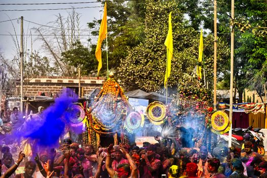 Colorful Holi celebration with crowd enjoying the festival in India, throwing vibrant powders in the air.