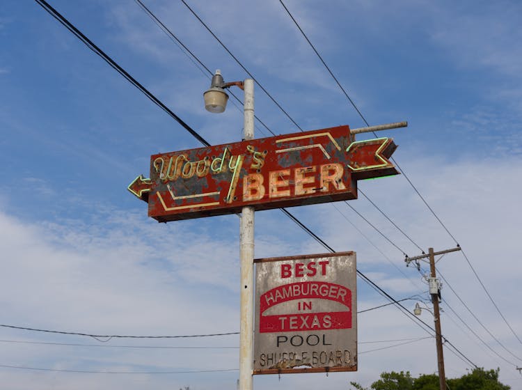 A Vintage Rusty Signpost Of The Woody Bar And Grill In Texas, USA