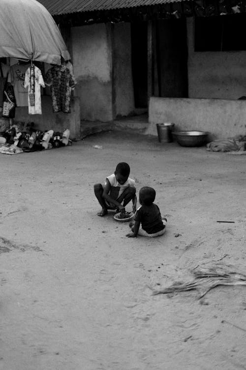 Black and White Photo of Children Playing on the Ground Outside