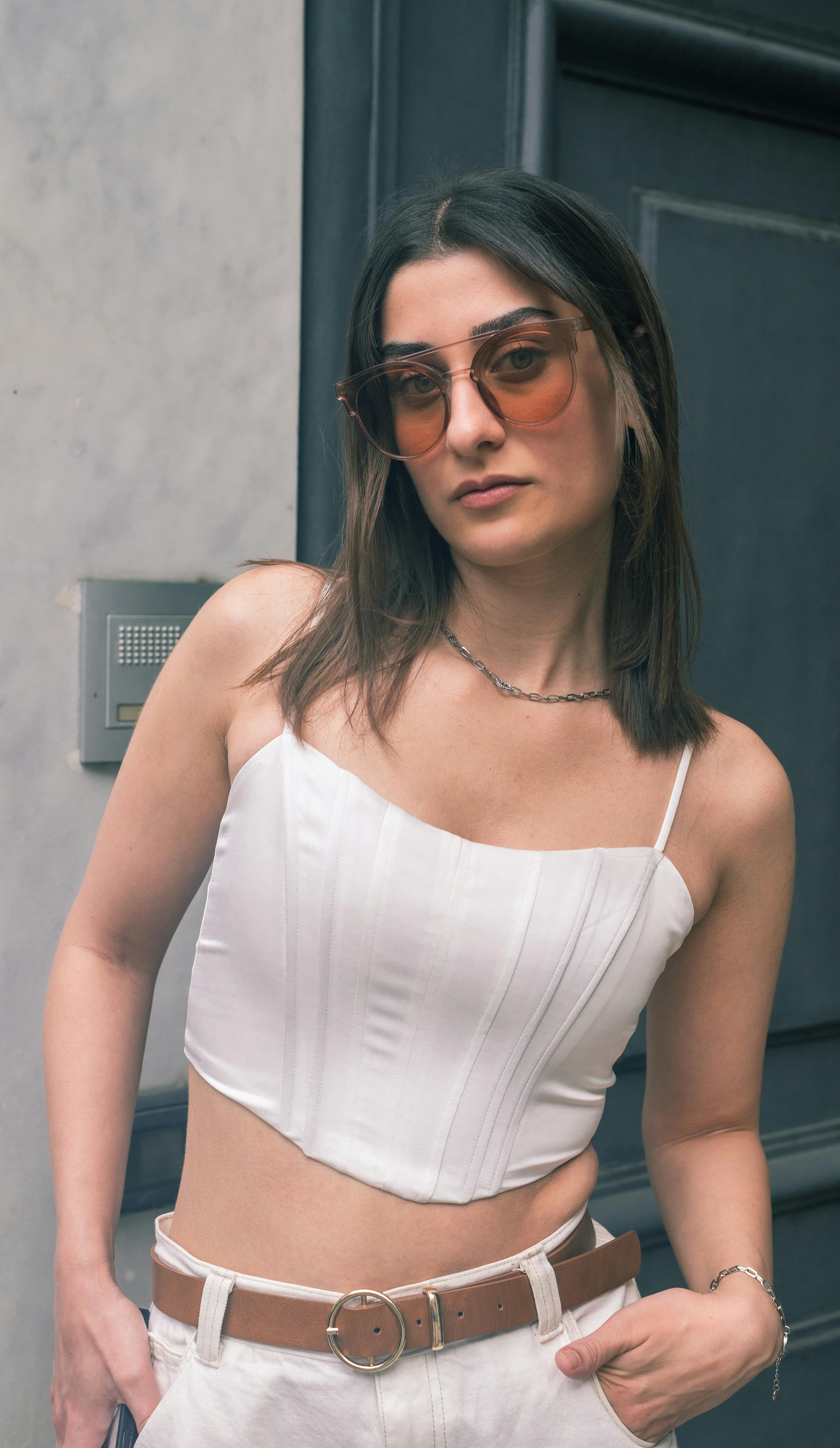 Stylish woman in white attire poses confidently, showcasing summer fashion.