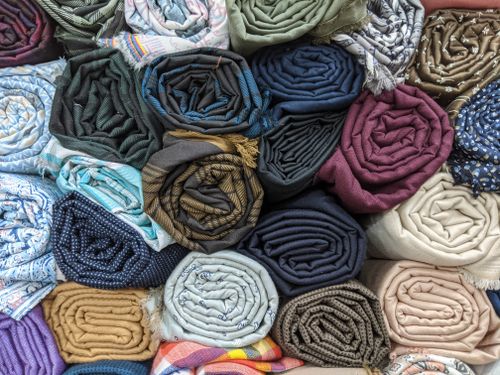 Free A colorful and diverse selection of rolled fabrics stacked in a top view flat lay arrangement. Stock Photo