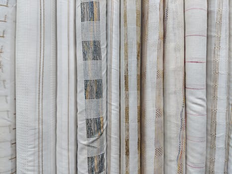 Monochrome fabric rolls displaying elegant, subtle patterns and textures for interior design.