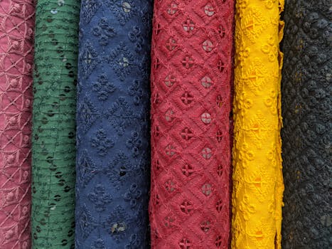 A close-up view of colorful textured fabric rolls in various patterns and hues.