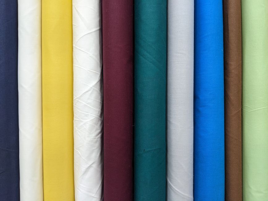 An array of satin hair accessories including scrunchies, bonnets, and pillowcases in various colors