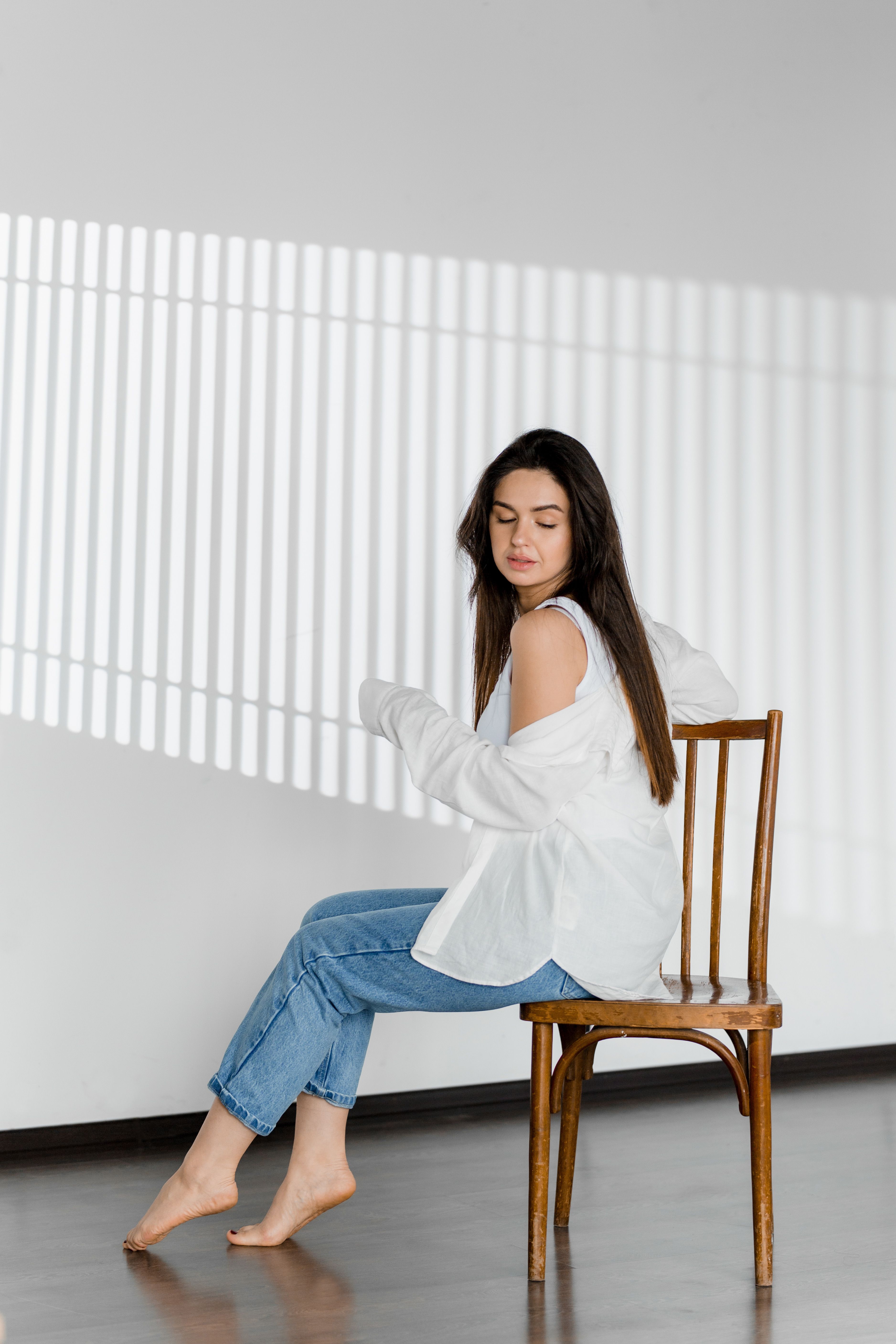 Woman in Jeans and White Shirt on Chair · Free Stock Photo