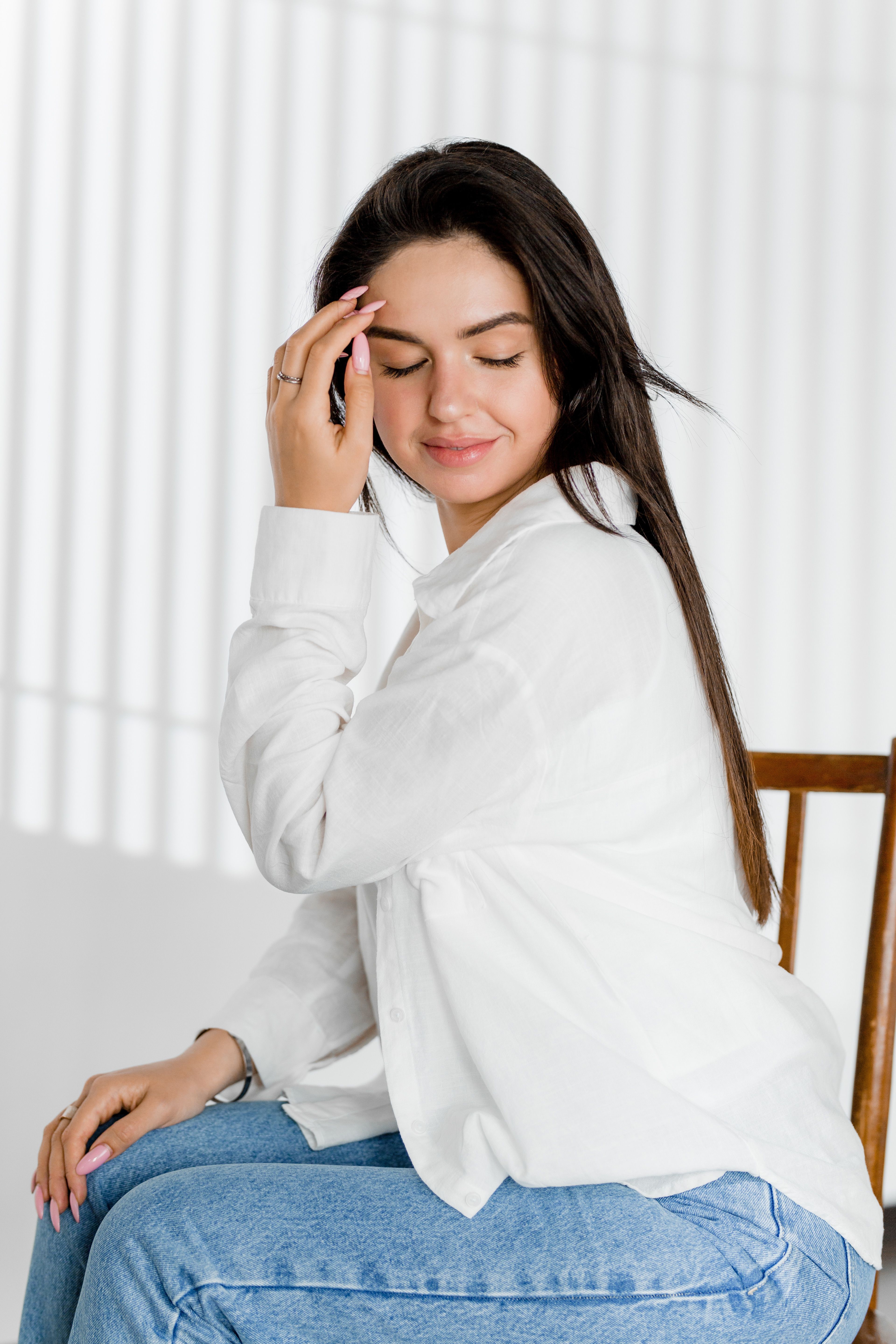 Modest Woman Fixing Hair and is Sitting on Chair · Free Stock Photo