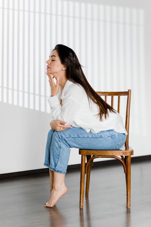Barefoot Woman in Jeans on Chair