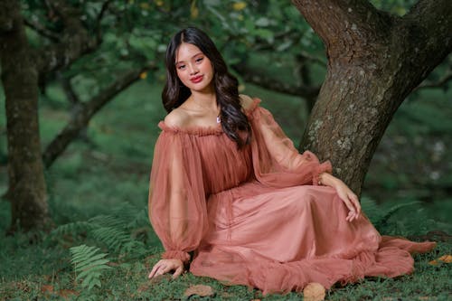 Woman in Dress Smiling and Posing by Tree