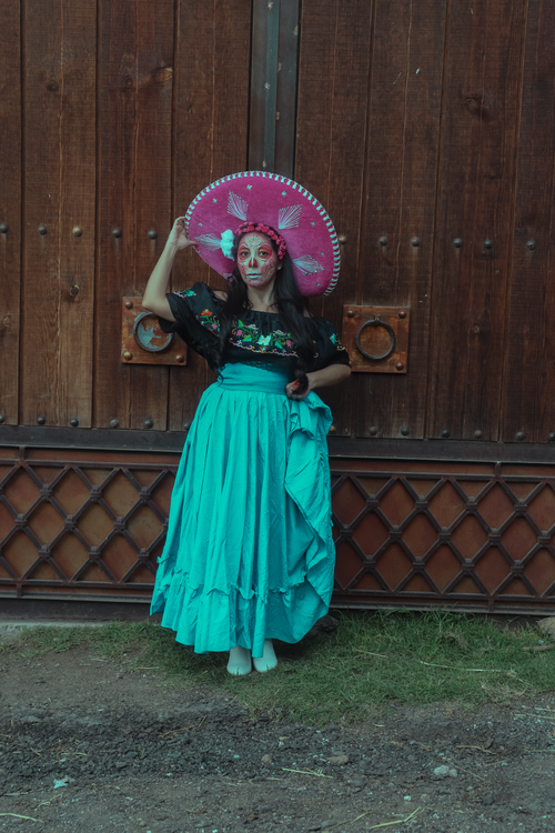 Free Woman in traditional Mexican dress and skull makeup celebrating Día de Muertos. Stock Photo
