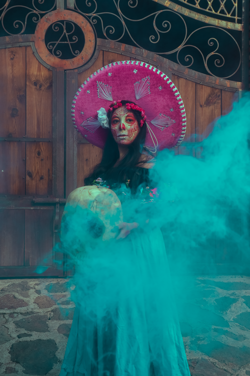 Free Colorful Dia de los Muertos celebration with traditional costume and vibrant smoke in Mexico City. Stock Photo
