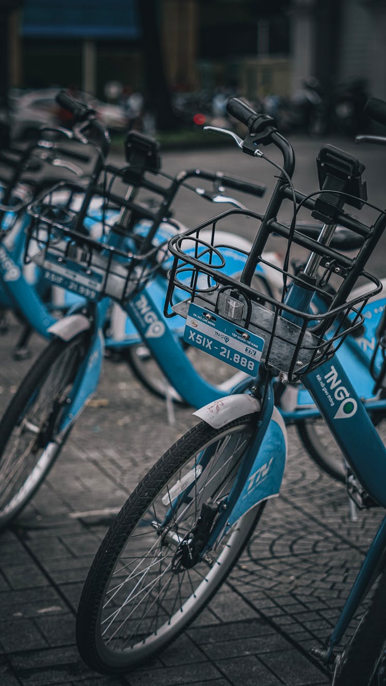 Row Of Blue Public Bicycles Parked On A City Street