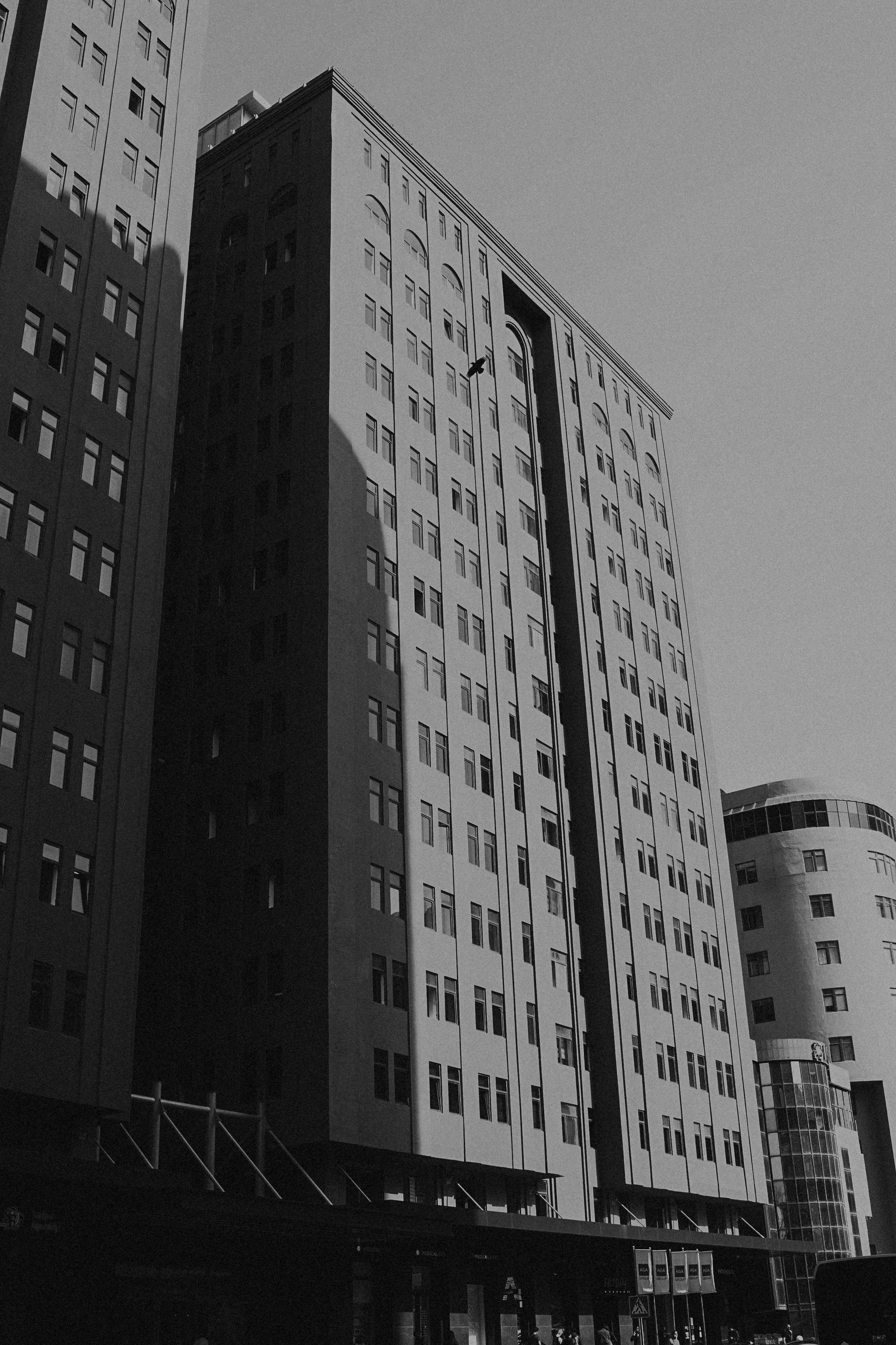 Tall modern apartment buildings in an urban setting, captured in black and white.