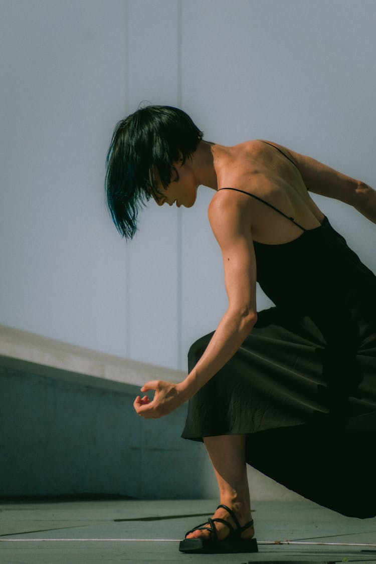 Woman In Silk Black Dress Flexing Muscles