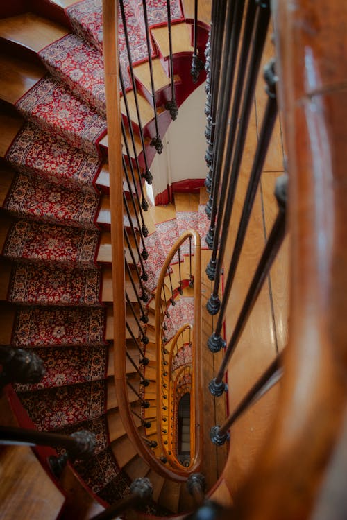 High Angle Shot of a Staircase with a Red Rug 