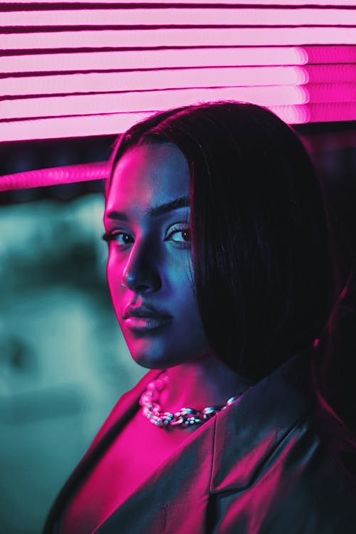 Photo of a Young Woman in Pink Lighting 