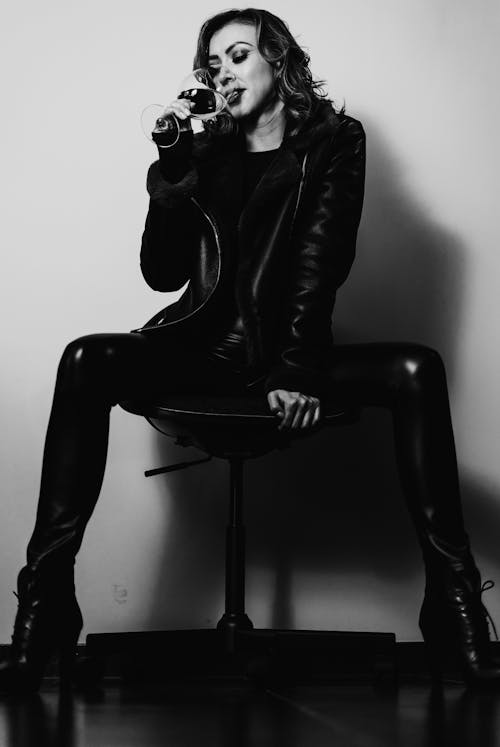 Woman in a Leather Outfit Drinking Wine
