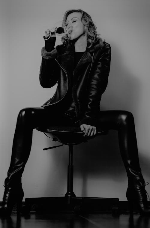 Woman in Jacket Sitting and Drinking in Black and White