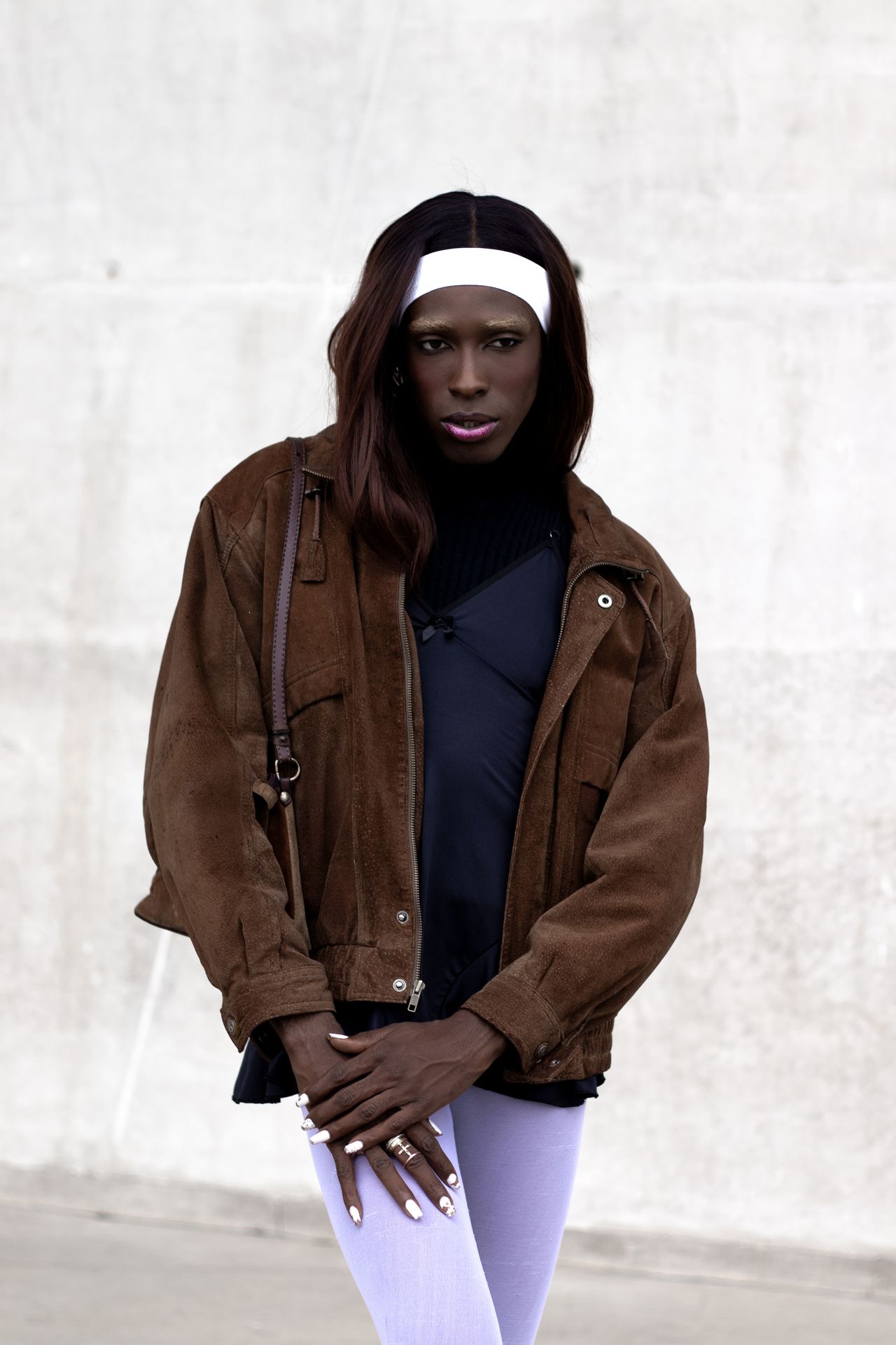 Model wearing an oversized chocolate brown suede jacket over a black top with light leggings