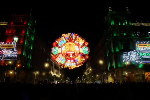 Colorful neon lights illuminate the historic Zócalo square in Mexico City, showcasing Aztec designs.
