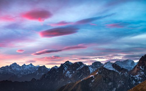 Free Captivating sunset over the snow-covered peaks of the Dolomites, with vivid pink and blue skies. Stock Photo