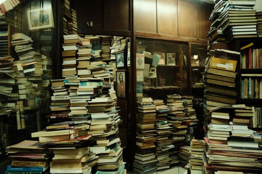 A cluttered, vintage bookshop with stacks of books and a warm ambiance.