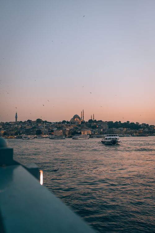 Free Scenic view of Istanbul skyline with boats on the Bosporus at sunset, showcasing iconic landmarks. Stock Photo