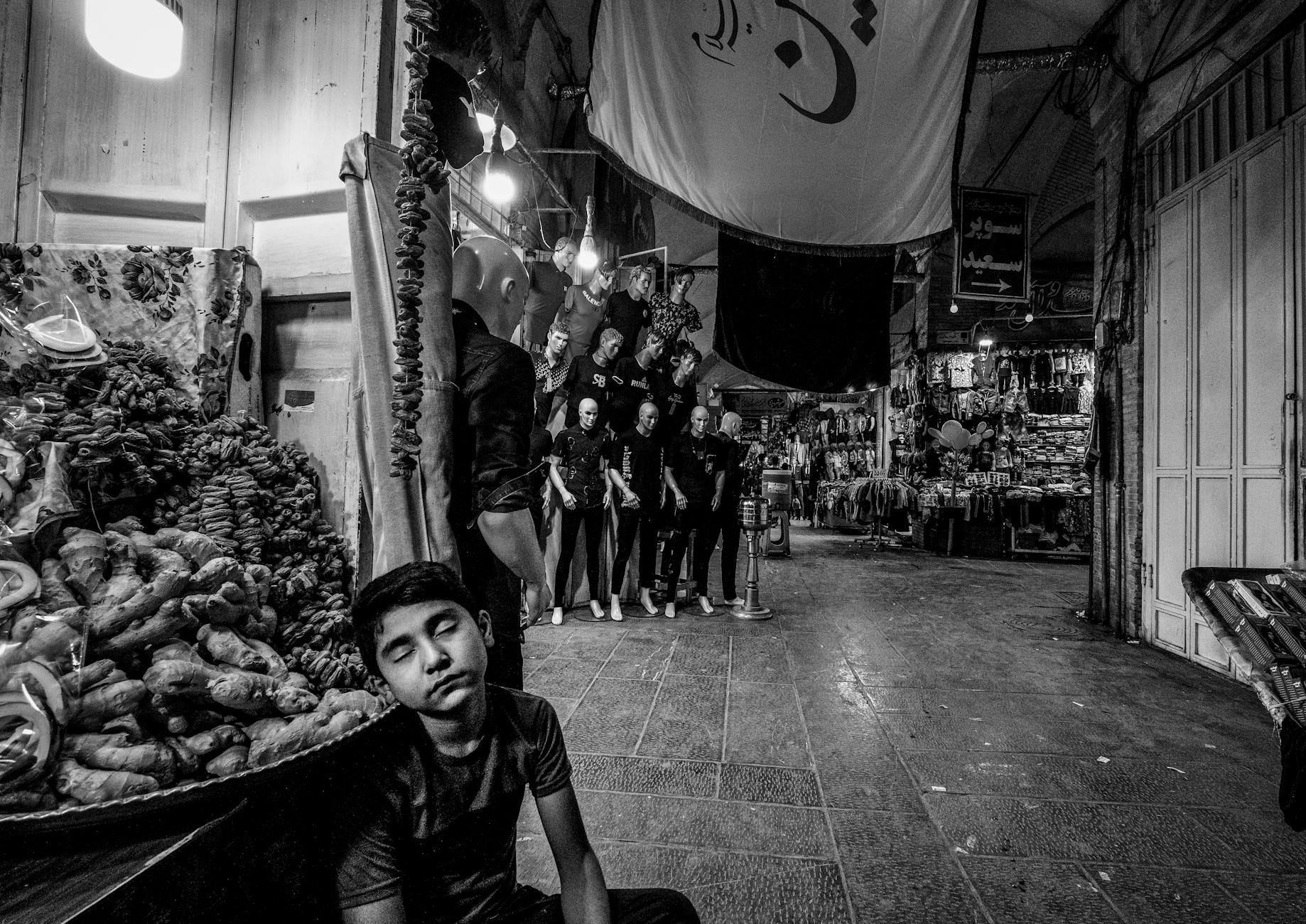 https://www.pexels.com/photo/child-sitting-at-bazaar-in-black-and-white-18362159/