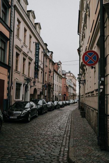 Explore a narrow cobblestone street lined with historic buildings in Riga, Latvia.