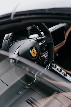 Close-up of a Ferrari sports car steering wheel showcasing luxury design and craftsmanship.