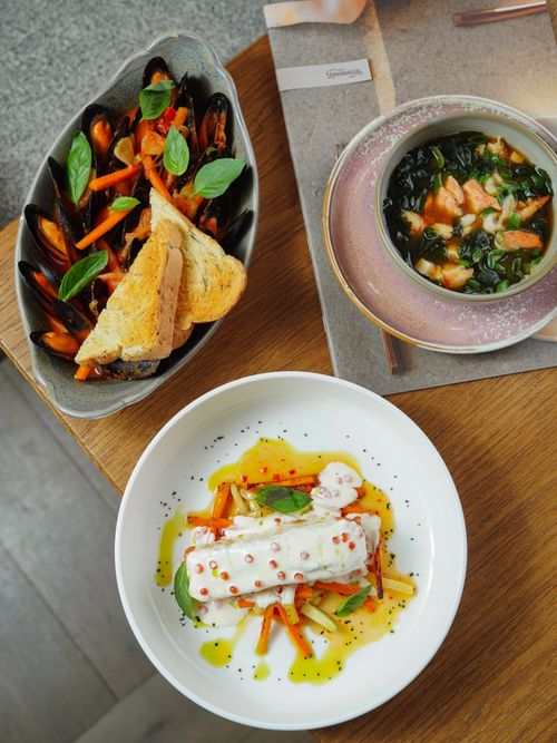 Free A vibrant display of seafood and vegetable dishes presented with artistic flair in a restaurant setting. Stock Photo