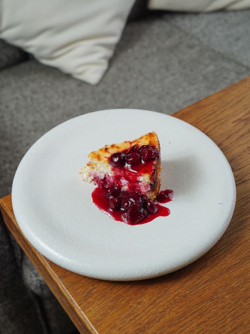 Free A close-up of a slice of berry cheesecake with rich sauce on a white plate, perfect for dessert lovers.  Stock Photo