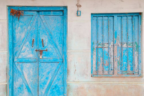 Blue Wooden Door and a Barred Window