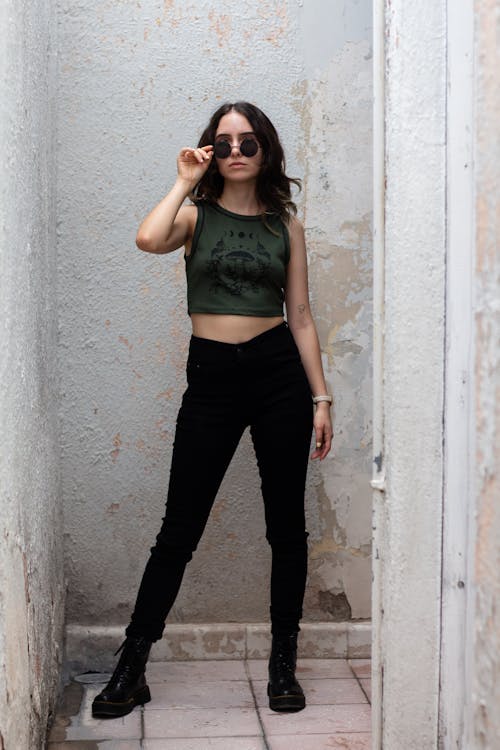 Woman in a Green Tank Top and Black Pants 