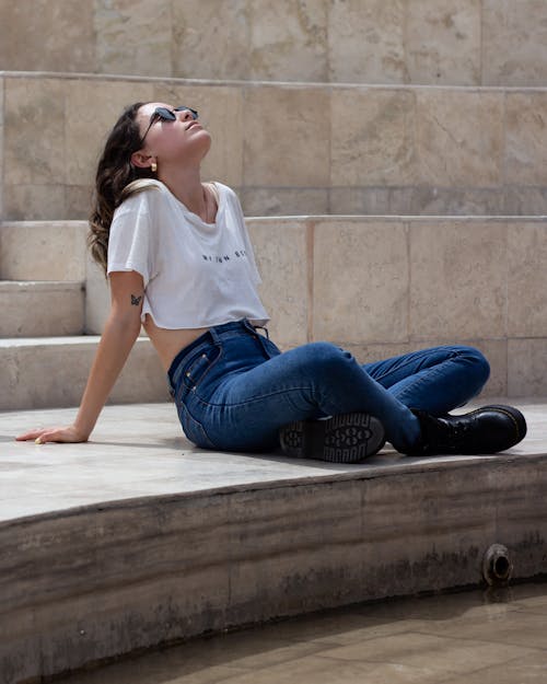 Young Brunette Wearing a Crop Top Relaxing on Outdoor Steps