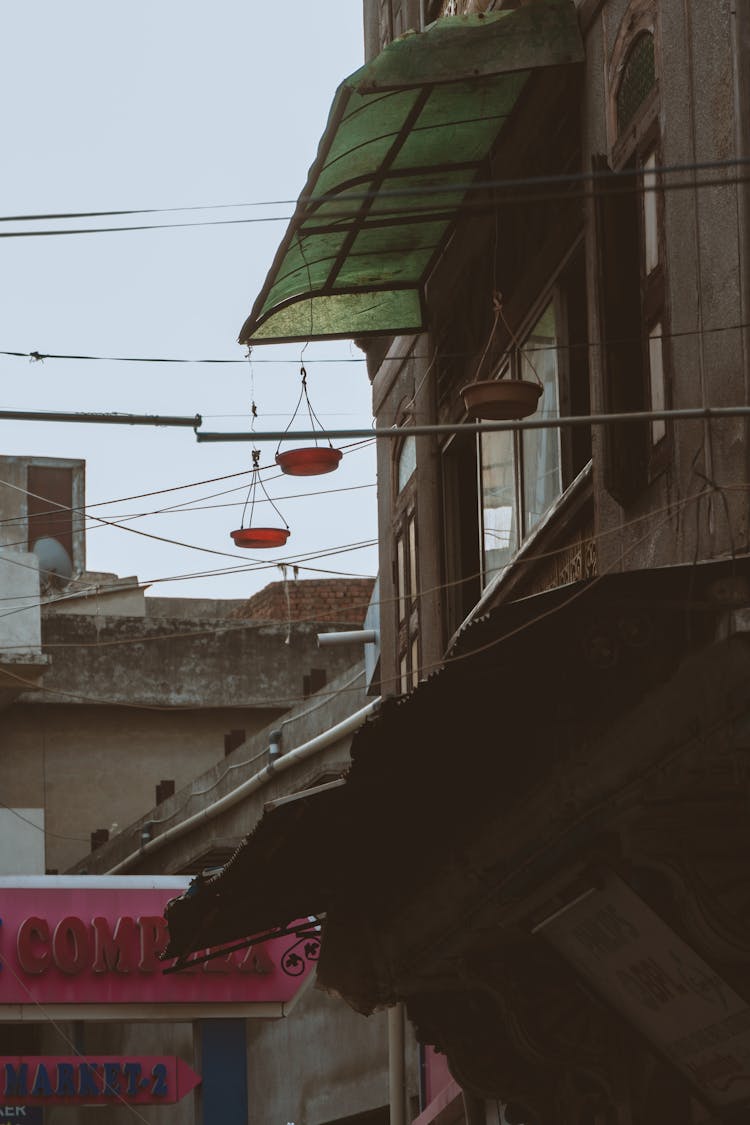 Bowls Hanging On Lines Near Building Windows