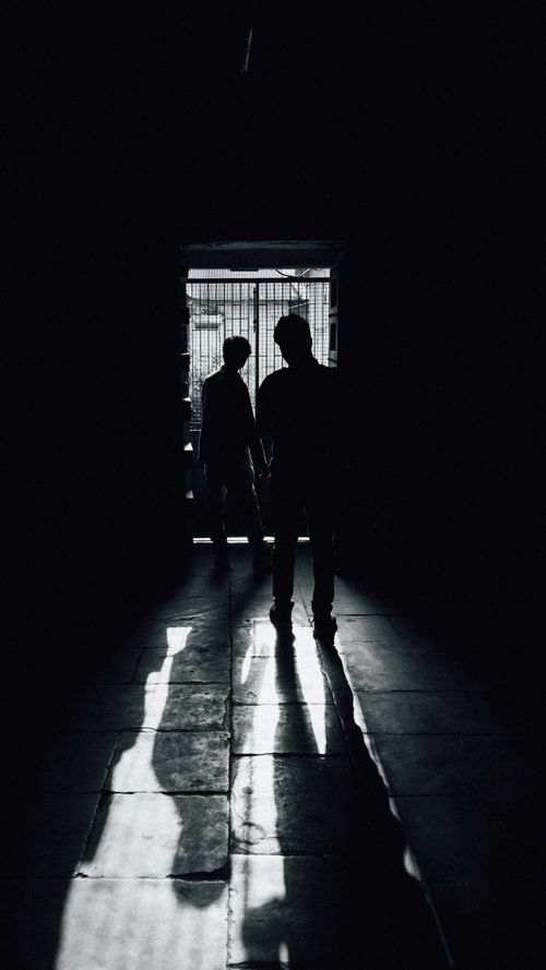Free Artistic black and white photo of two silhouettes in a corridor, highlighting shadows and light. Stock Photo