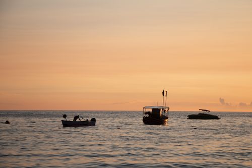 Free Boats silhouetted against a stunning sunset in Vlorë County, Albania. Stock Photo