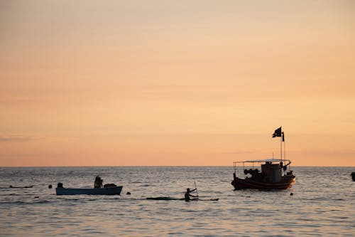 Motorboat and Boats on Sea Coast at Sunset